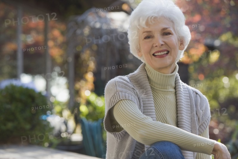 Portrait of senior woman sitting in garden. Photographe : mark edward atkinson