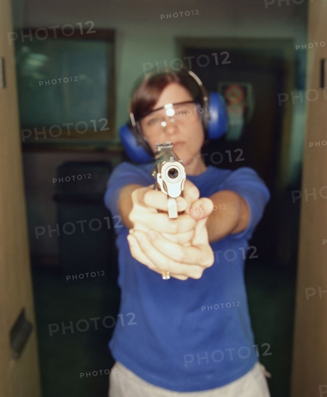 Young woman holding gun. Photographe : Stewart Cohen