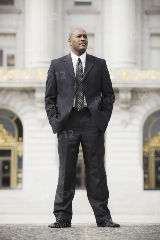Businessman standing outside office building, San Francisco, California, USA. Photographe : PT Images