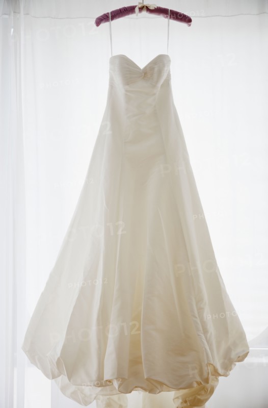 Wedding dress on hanger, studio shot. Photographe : Jamie Grill