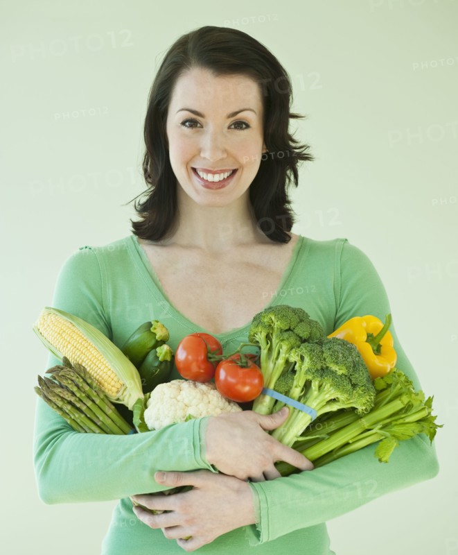 Woman holding various vegetables.