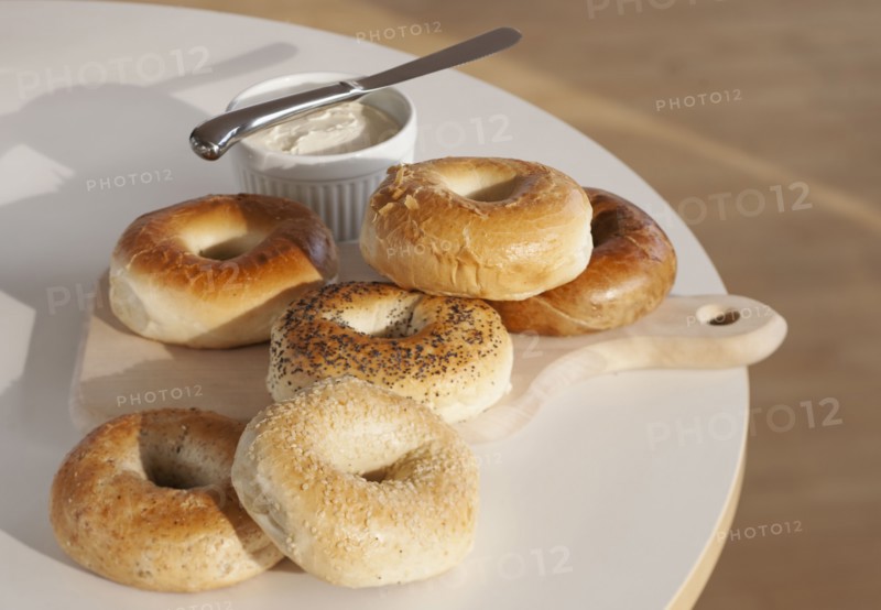 Bagels and creme cheese on table.