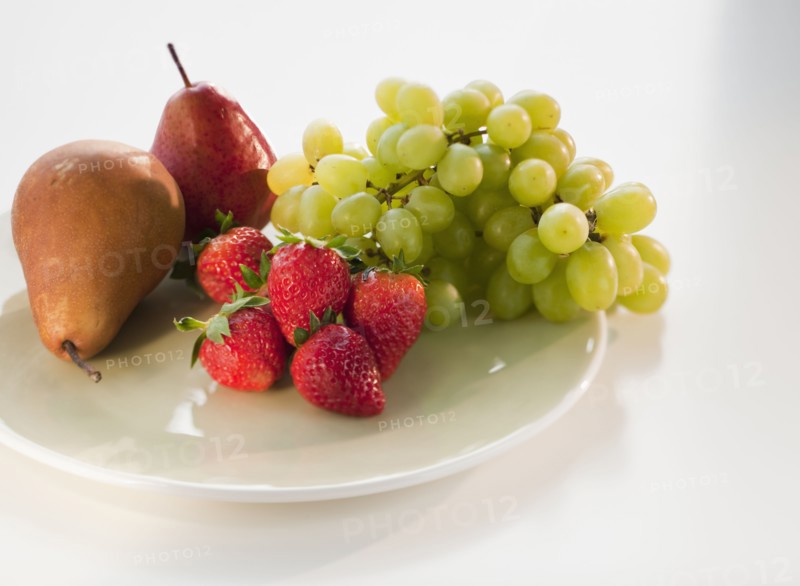 Pears, grapes and strawberries on plate.