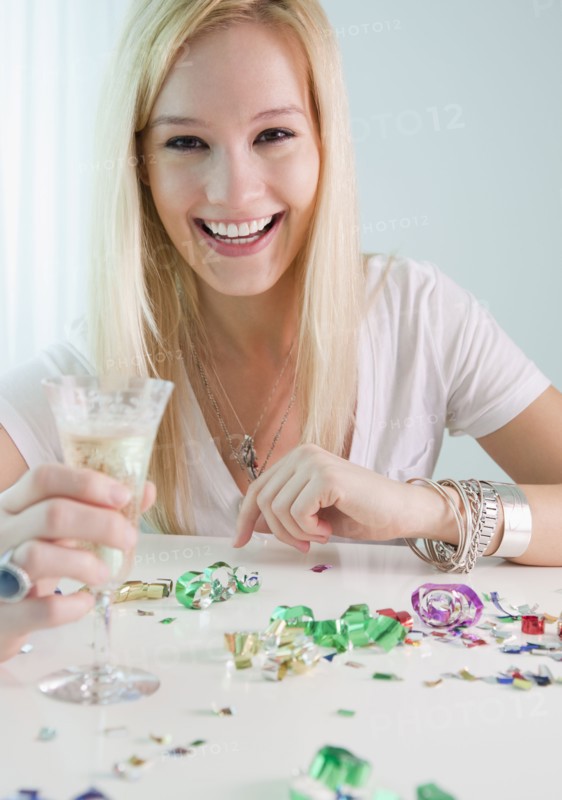 Portrait of young woman holding champagne and new year's eve. Photographe : Jamie Grill