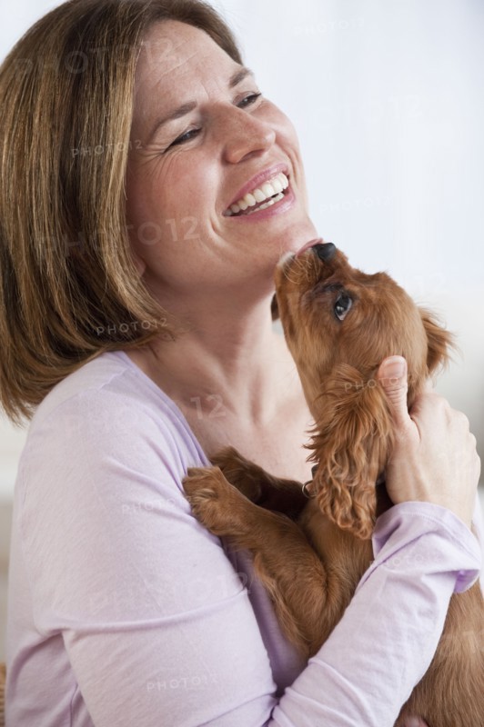 Mature woman hugging puppy.
