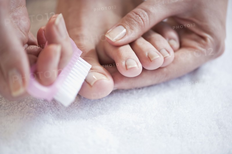 Woman caring for her toenails. Photographe : Daniel Grill
