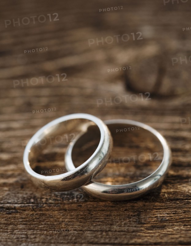 Two wedding rings on wooden table. Photographe : Jamie Grill