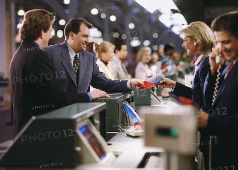 Businessman buying ticket at the airport. Photographe : Stewart Cohen