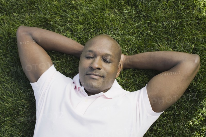 Bald man relaxing on grass. Photographe : PT Images