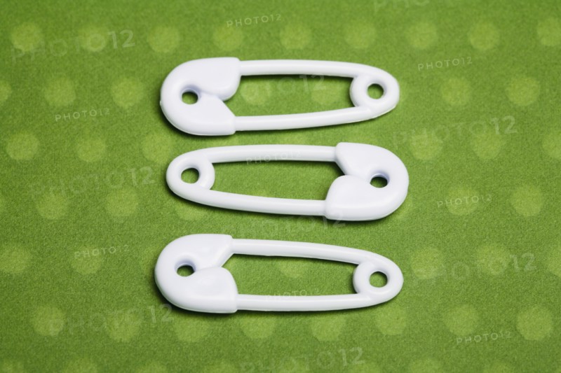 Three safety pins. Photographe : Kristin Lee