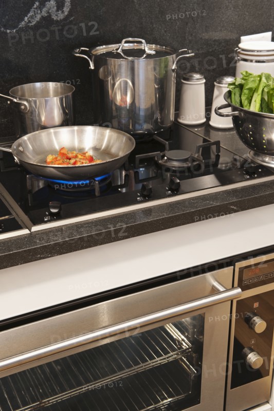 Vegetables in frying pan on cooker.