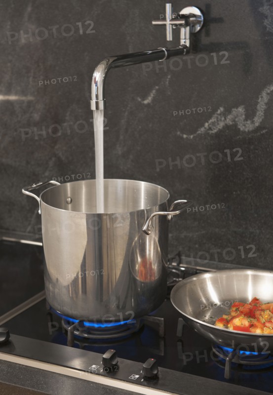 Water pouring from tap into pot.