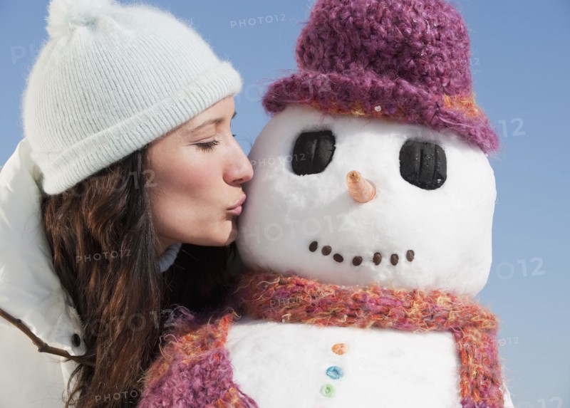 Woman kissing snowman.