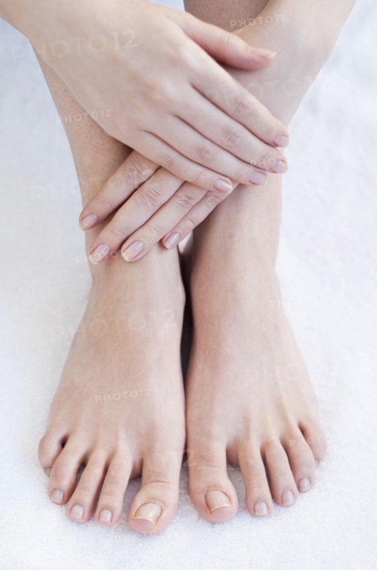 Close-up of woman's hands and feet.