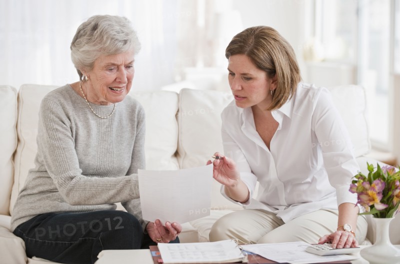 Mature woman giving financial advice to senior woman.