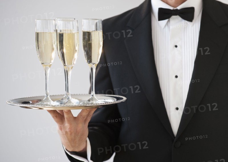 Champagne being served on a silver tray.