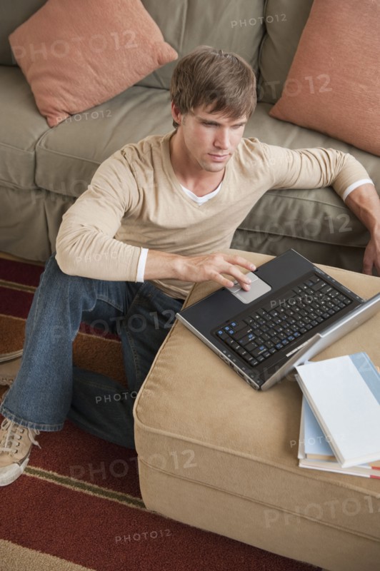 Man using laptop in living room.
