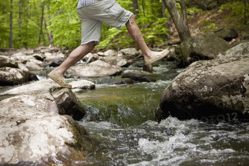A man at a stream in the woods