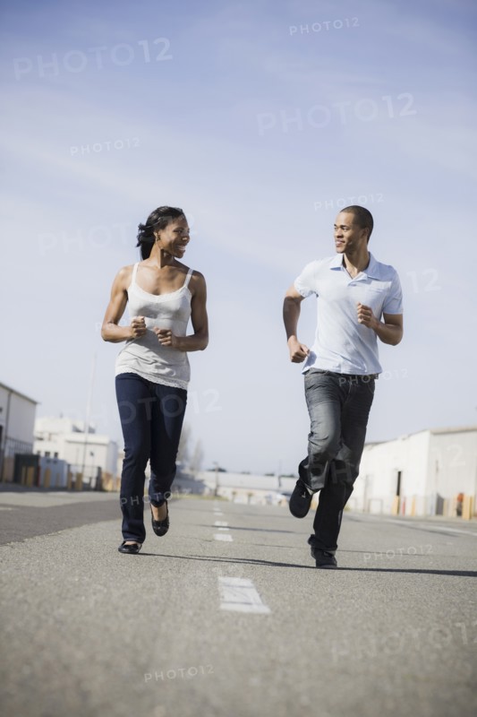 A couple running on road outdoors