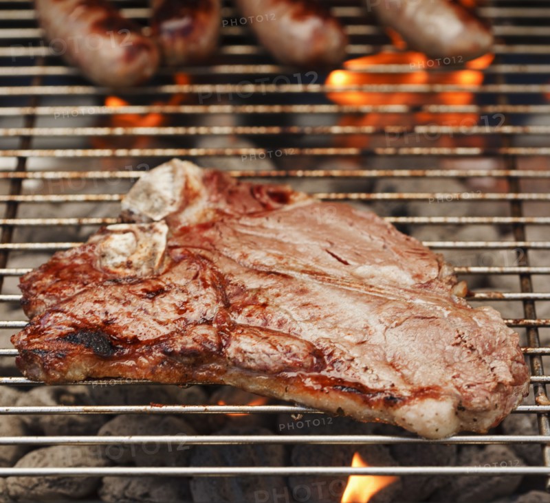 Steak and sausages on a barbeque