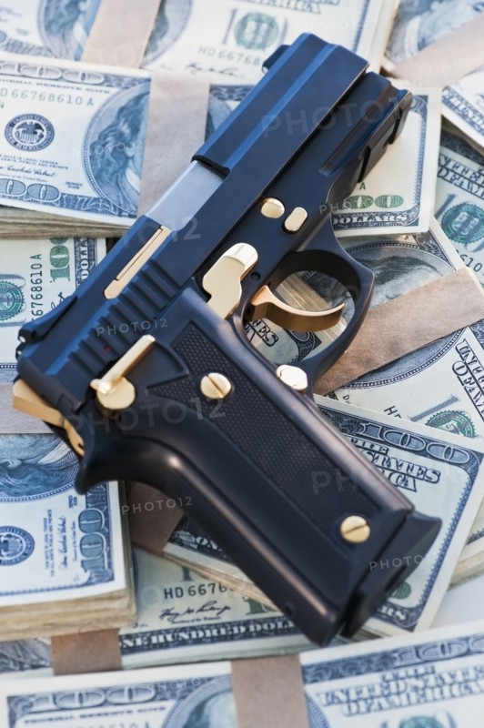 A handgun on stacks of money