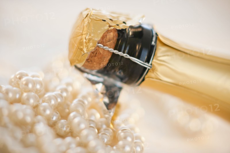 Champagne bottle and pearl necklace.
