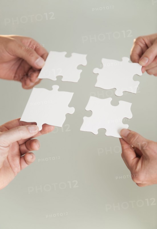 Hands holding puzzle pieces.