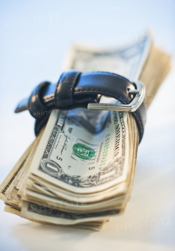 A watch around a stack of money.