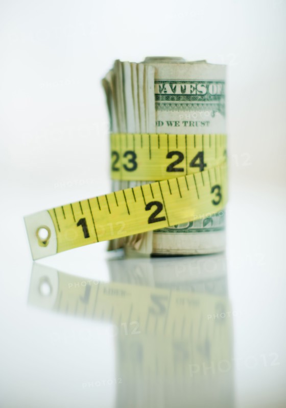 A measuring tape around bank notes.