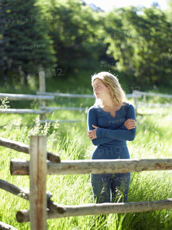 Young woman behind fence