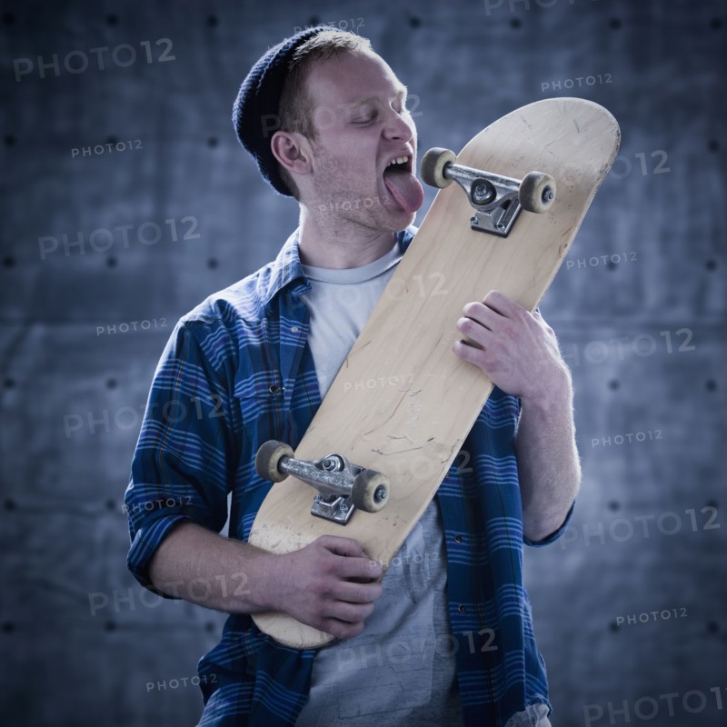 Male skateboarder licking board