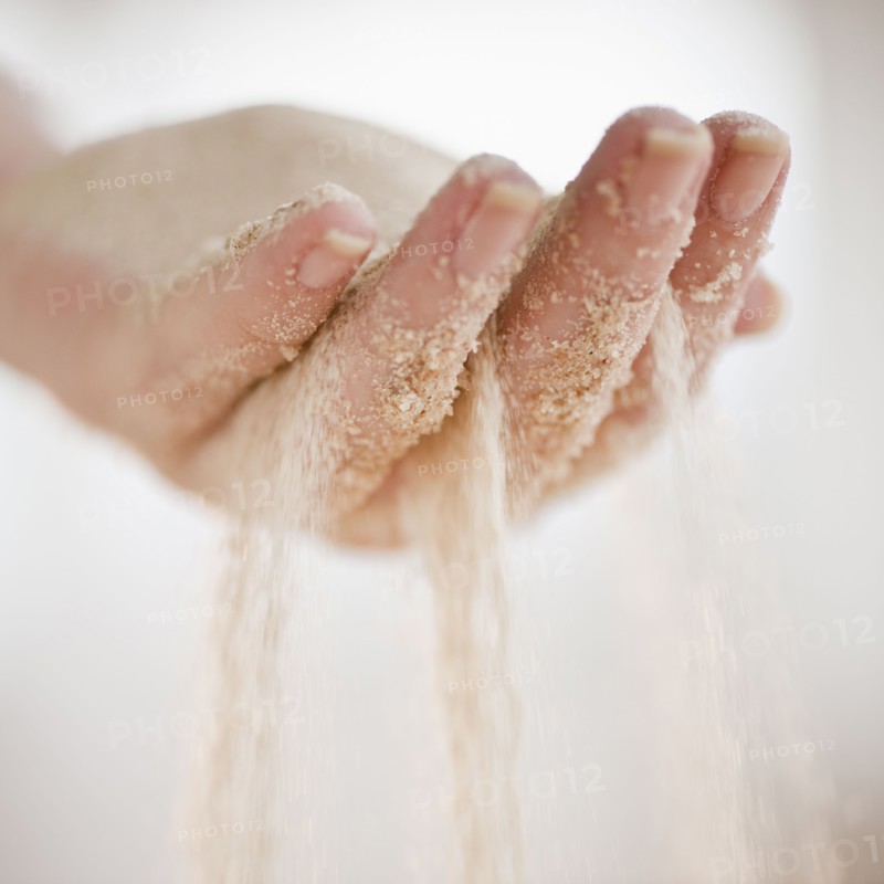 Sand grains falling through hand.