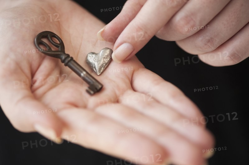 Hands holding heart and key.