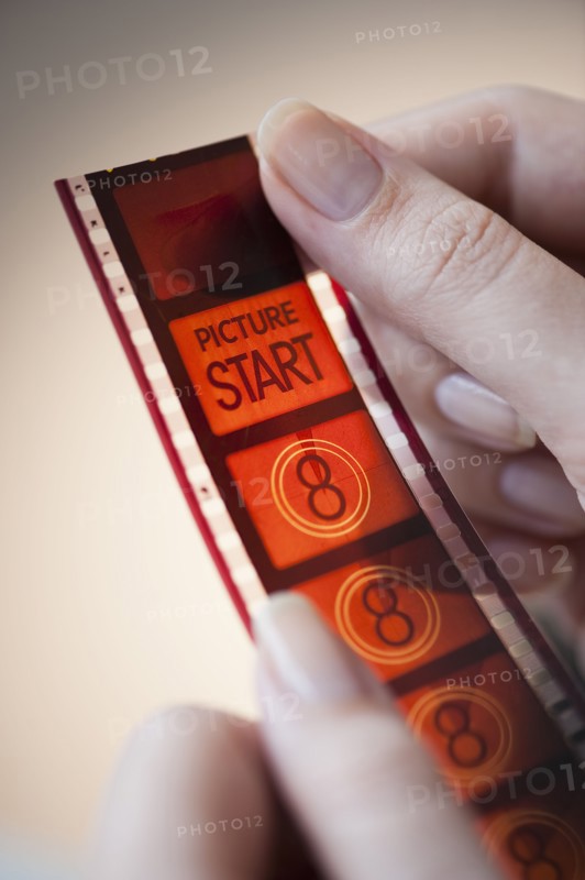hands holding film strip.