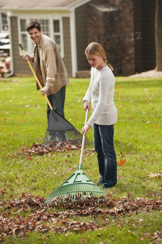 Man and girl raking leaves.