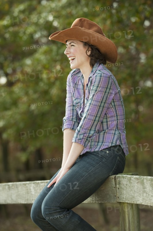 Woman sitting on fence.
