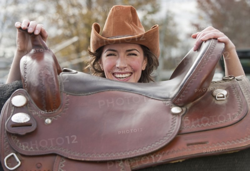 Woman holding saddle.