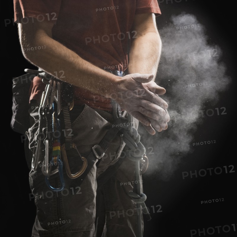 Male climber applying chalk to hands