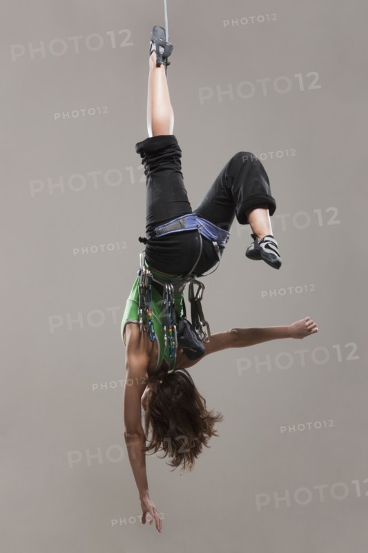 Female Climber hanging upside down
