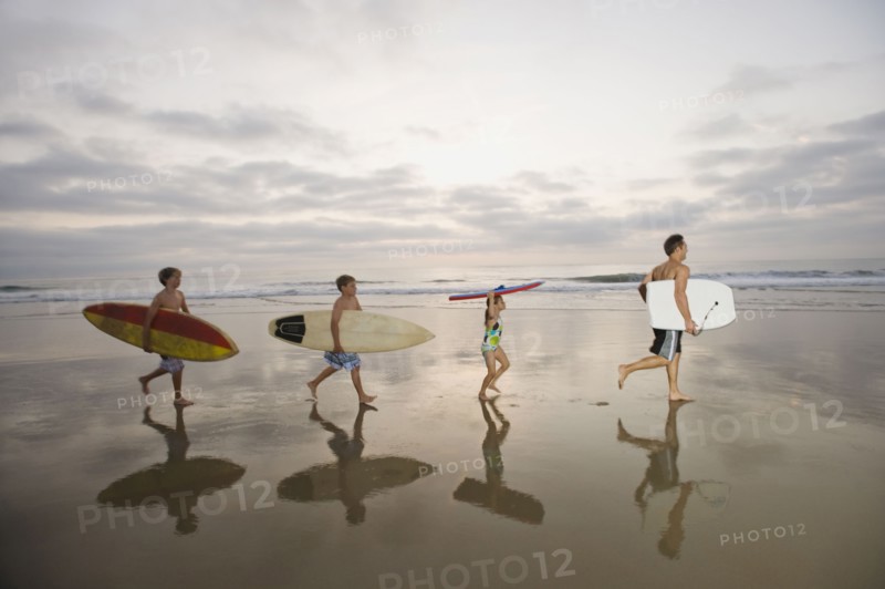 Family carrying surfboards