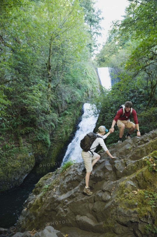 Hikers in front of waterfall