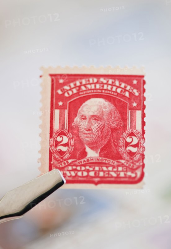 Tweezers holding stamp.