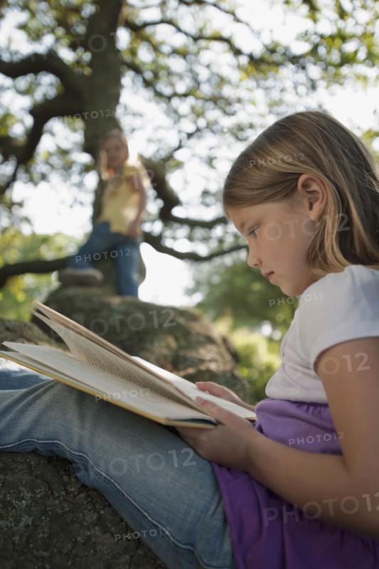 Girl reading book in tree