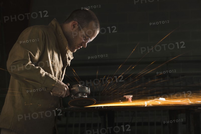 Steel grinder working in metal shop