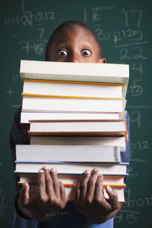 Boy holding stack of books