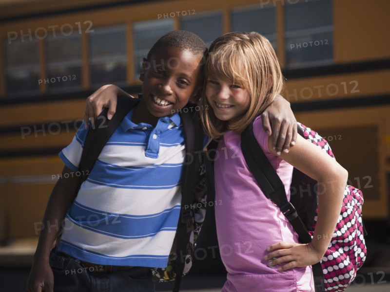 Friends in front of school bus