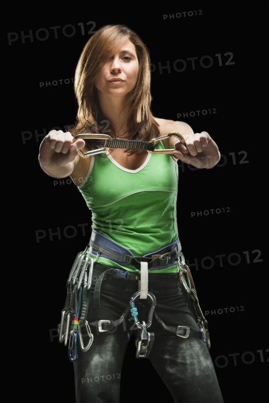 Studio shot of a female climber holding carabiners