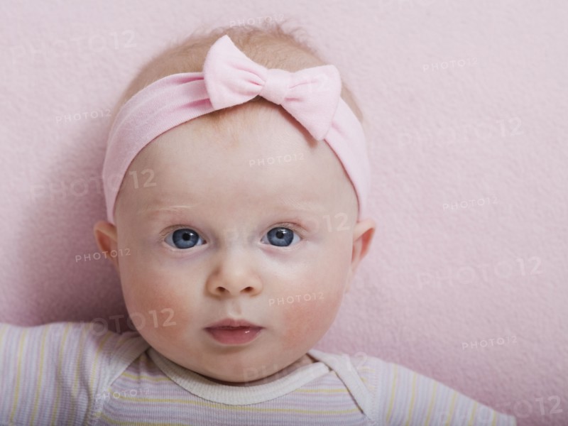 Portrait of baby girl with pink ribbon