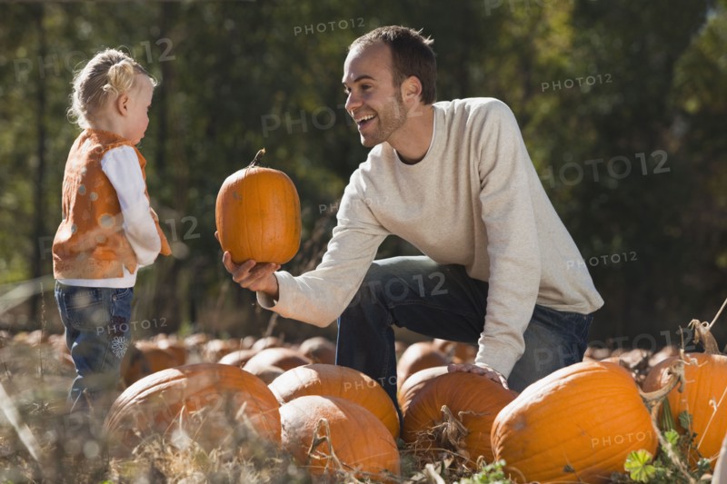 Father and daughter in pumpkin patch. Photographer: Mike Kemp