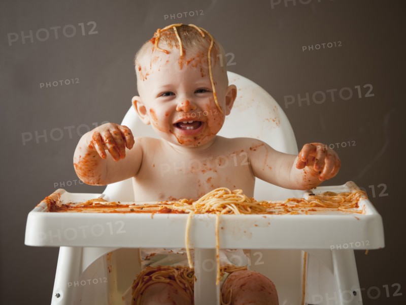 Baby covered in spaghetti. Photographer: Mike Kemp